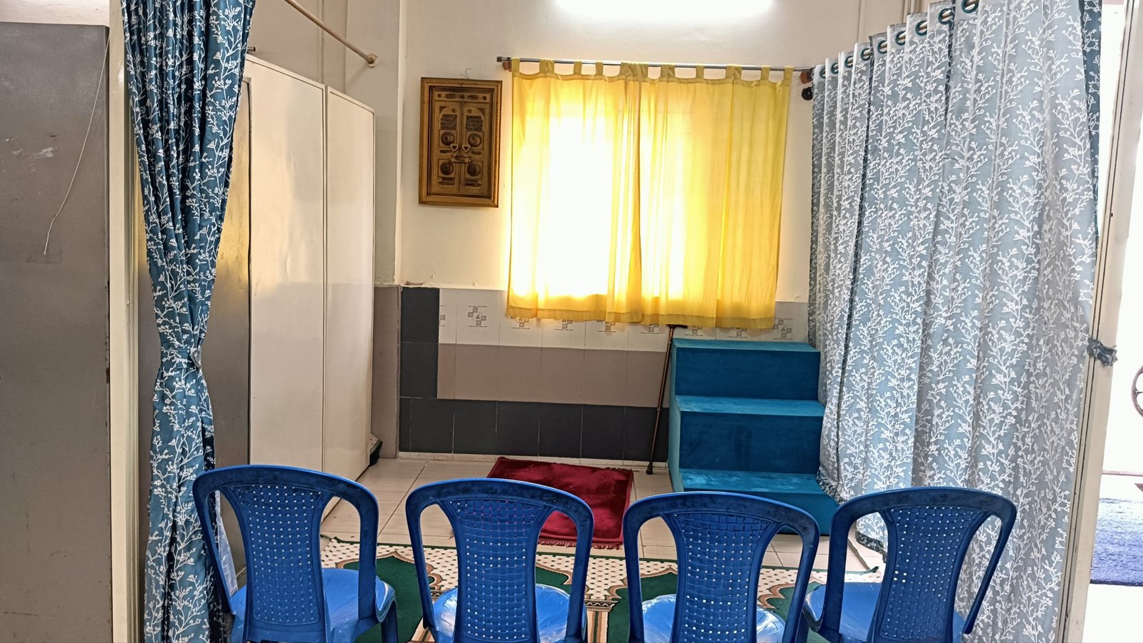 A wider view of the prayer room, with seating for residents and light through the windows