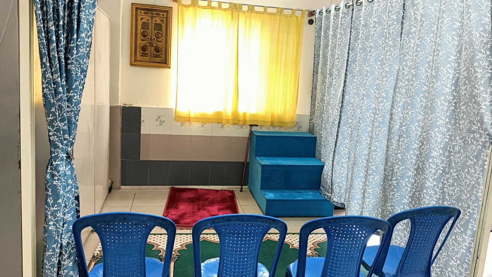 The prayer room, with prayer mats, a small pulpit, and framed religious art
